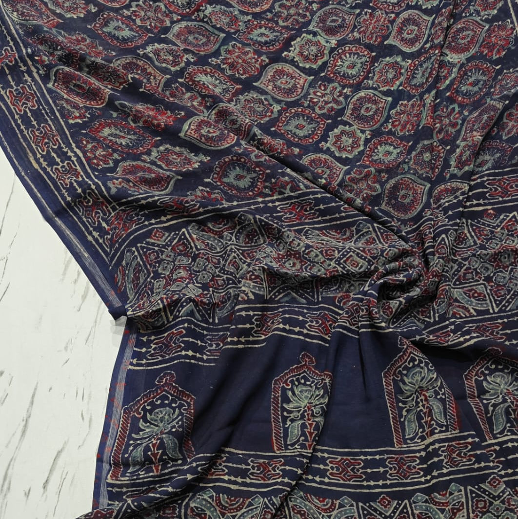 Navy blue chiffon saree with intricate patterns on a light wooden surface