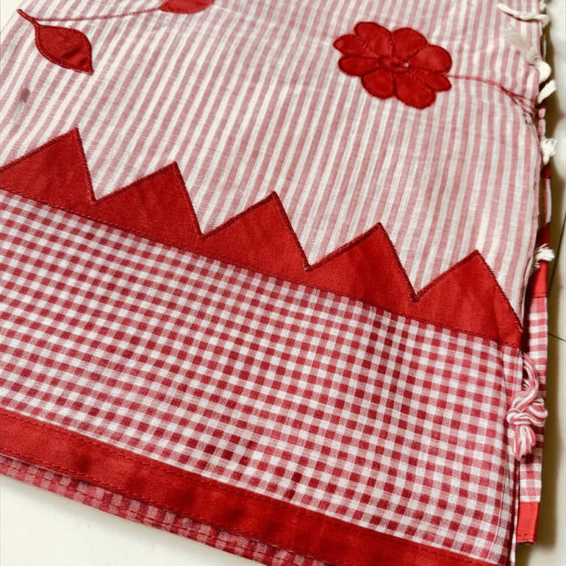 Red and white checkered fabric with floral patterns, branded 'Saachi'.