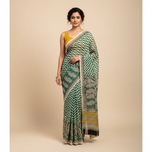 A folded chiffon saree with a green and white chevron pattern, a wide border with beige and black paisley motifs, and yellow and black stripes, displayed on a white marble surface.