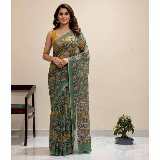 Green floral patterned saree draped over a chair with a plant in the background