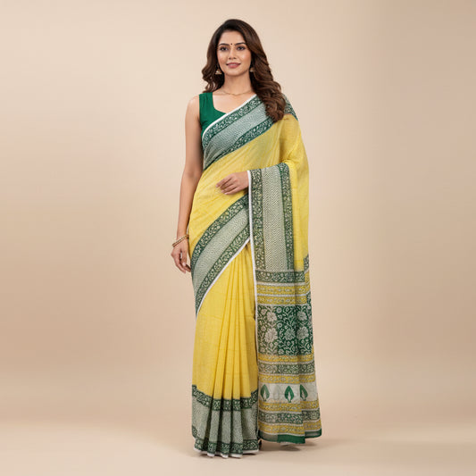 A folded chiffon saree with a bright yellow body and a wide border featuring green and yellow floral patterns, displayed on a white marble-textured surface.